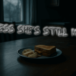 A cold grilled cheese sandwich and a few potato chips sit on a white plate on a kitchen table in dim December dusk light, with an empty space where a highchair should be.